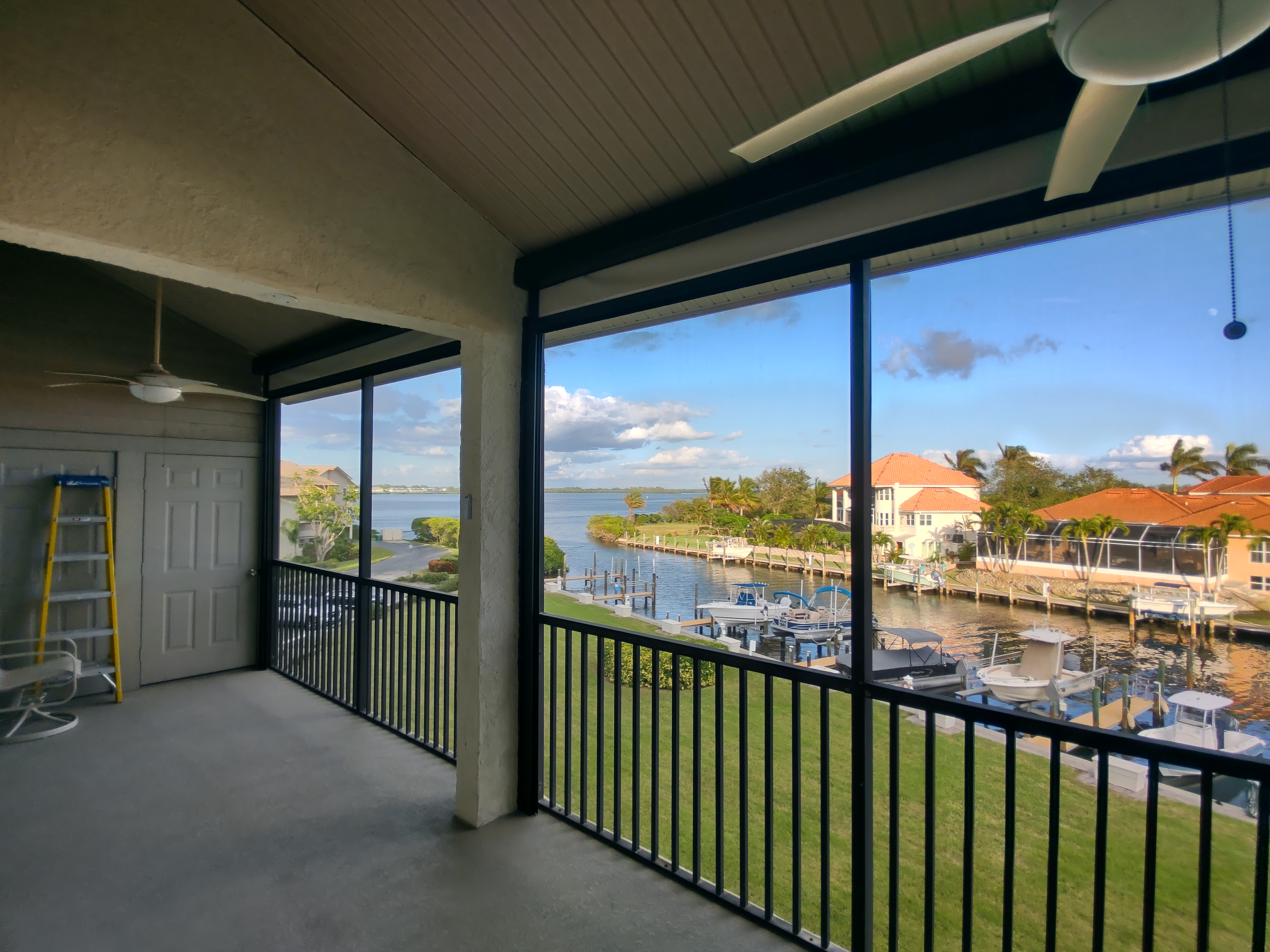 Waterfront lanai with roll-down screens overlooking a Florida canal and boats