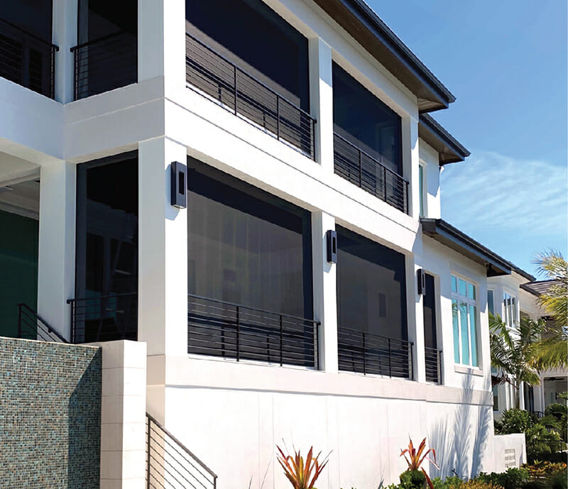 Modern home with motorized retractable screens protecting windows