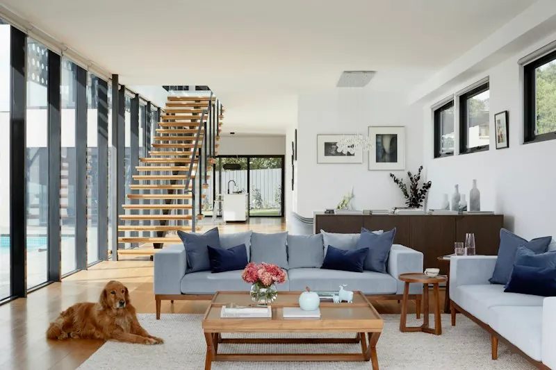 Bright living room with large glazed doors and a dog beside the sofa